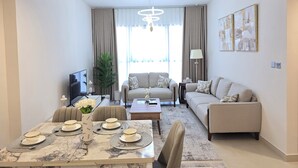 A modern living room with a dining area, a sofa set, and a TV.