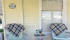 A porch with two wicker chairs, a small table with a potted plant, and a 'STAY AWAY' sign on the wall. - FREE NIGHT•KNOTTY ESCAPE• Hikers Haven in RRG• Walk to Attractions • Hot Tub• (Campton)