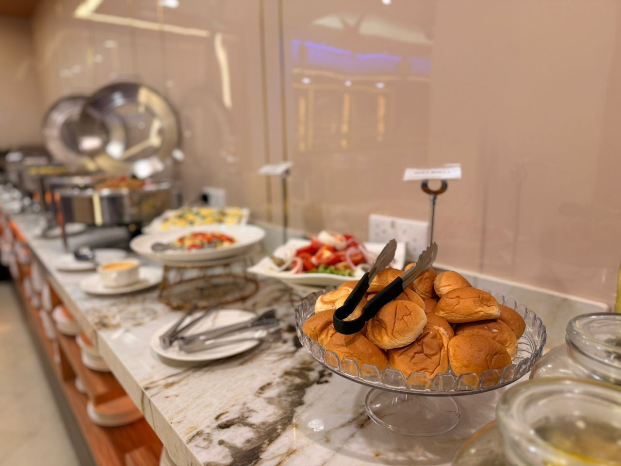 A buffet setup with various food items and utensils.