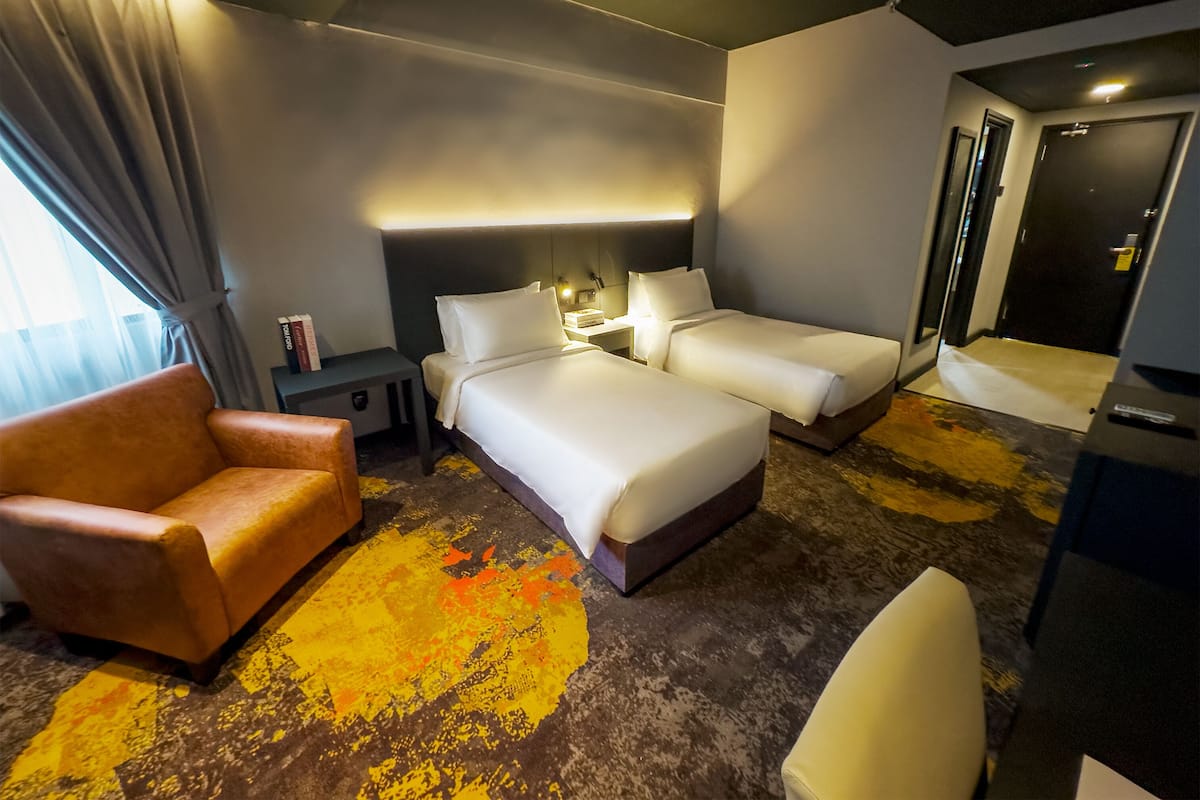 A hotel room with a bed, two bedside tables, a chair, and a desk.