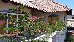 Une maison avec un toit en tuiles, une fenêtre et un mur sur lequel est affiché un panneau.