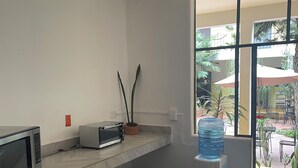A modern kitchen with a gas stove, a microwave, and a small oven. There is a water dispenser and a potted plant on the counter. - Located in downtown Morelia, 4 blocks from the imposing Cathedral. (Morelia)