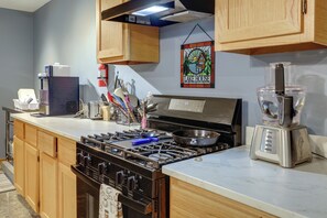 Una cocina equipada con estufa, horno, tostadora y licuadora.
