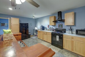 Una cocina moderna con armarios de madera, un refrigerador de acero inoxidable, una estufa y un microondas.