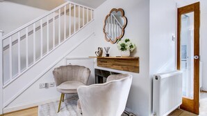 Una sala de estar moderna con una escalera, una chimenea y un radiador.