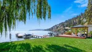 Una propiedad junto al lago con muelle, quiosco y zona de césped.