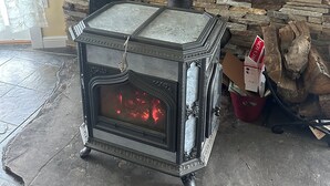 A wood stove with a digital display, set against a stone wall. - Casa Rotunda: A Cozy Catskills Escape (Margaretville)