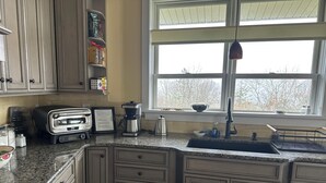 A kitchen with a built-in oven, a coffee maker, and a window above the sink. - Casa Rotunda: A Cozy Catskills Escape (Margaretville)