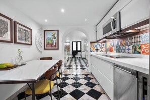 A modern kitchen with a checkered floor, white cabinetry, and a microwave above the counter.