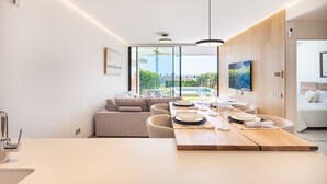 Eine moderne Küche mit Essbereich, großen Fenstern und Blick ins Freie.