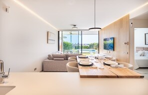 Een moderne keuken met een eethoek, grote ramen en uitzicht op de omgeving.
