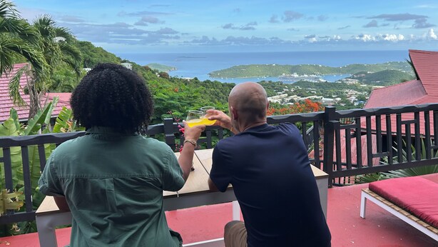 Two people seated at a table with a view of the sea and greenery. - Shibui Cove (St. Thomas)