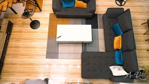 A modern living room with a sofa set, a coffee table, and a fan. - Experience the ultimate relaxation and privacy in Gray's Farmhouse. (Quezon)