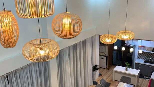 Um interior moderno com área de jantar, sofá e luminárias de teto.