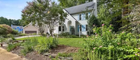 A residential property with a well-maintained garden, a driveway, and a garage.