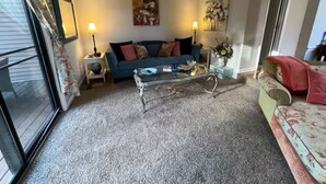 A living room with a sofa, a coffee table, and a lamp.