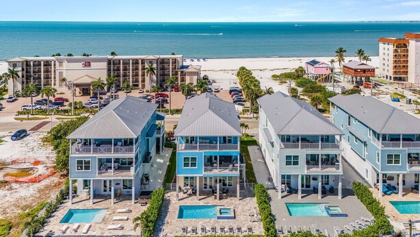 A coastal hotel with multiple buildings, a beach, and a marina. - Ocean Pearl Vacation Rental (Fort Myers Beach)