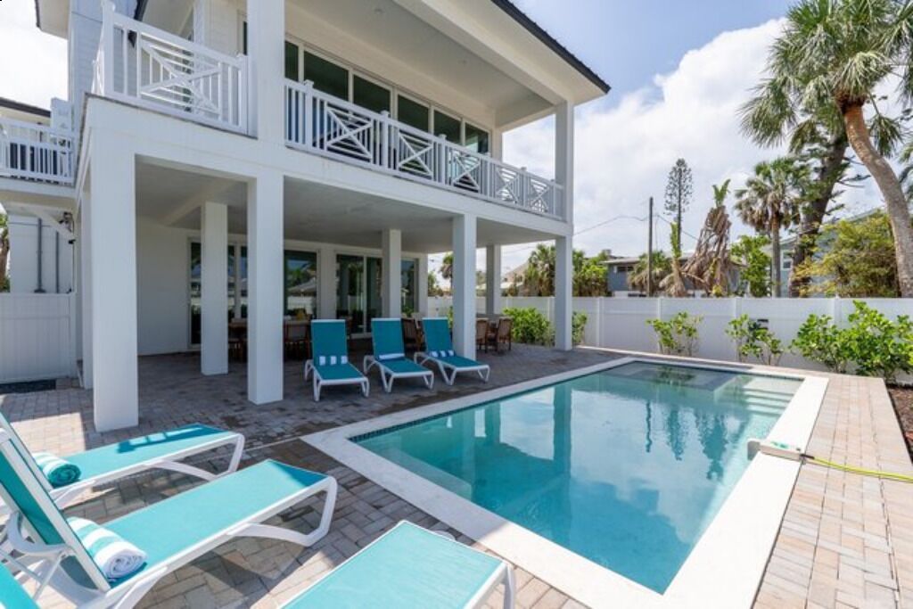 A two-story building with a pool and outdoor seating.