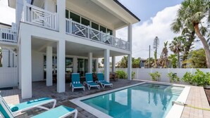 A two-story building with a pool and outdoor seating. - Saltwater Fantasea Vacation Home (Fort Myers Beach)