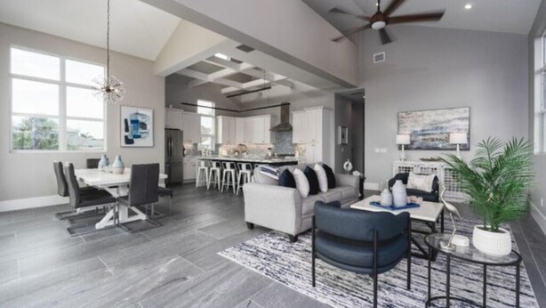 A spacious living area with a dining table, sofas, and a kitchen in the background. - Saltwater Fantasea Vacation Home (Fort Myers Beach)