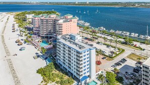 A resort with multiple buildings, a swimming pool, and a marina with boats. - Remodeled Beachfront Condo | Gulf Views | Pool (Fort Myers Beach)