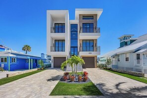 A modern multi-story residential building with a central courtyard, a garage, and a visible address number.