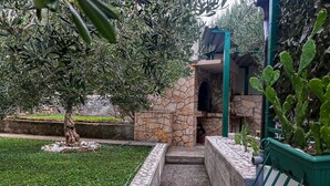 A stone-built outdoor area with a grill, surrounded by olive trees and cacti. - 1 bedroom gorgeous apartment in Duce (Duce)