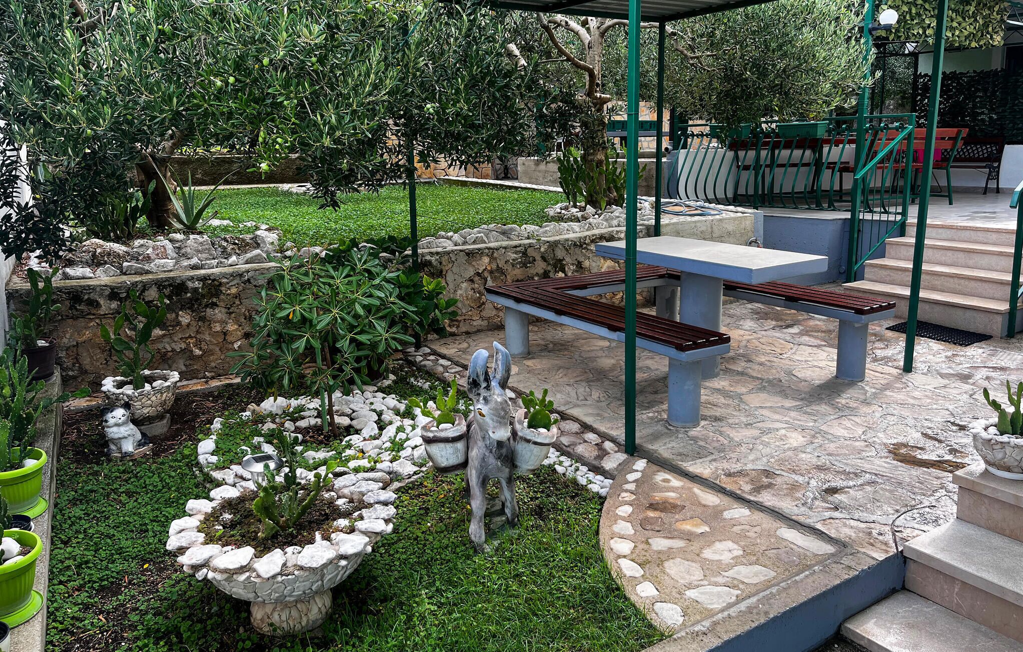 Un espace patio doté d’un sol en pierre, de sièges d’extérieur et de diverses plantes.