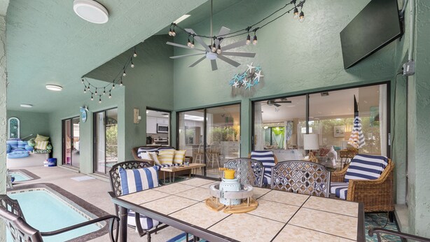 Une vaste terrasse extérieure dotée d’une piscine, d’un espace repas et de coins salon.