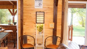 A wooden interior with a sofa, chairs, a table, and a sign indicating a boundary. - Waterfront Retreat for 8 w/Fire Pit, Boat Dock, no steps to water! 3BR/2BA (Cadiz)