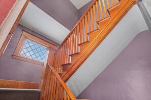 Una escalera de madera con un ventanal en la parte superior.