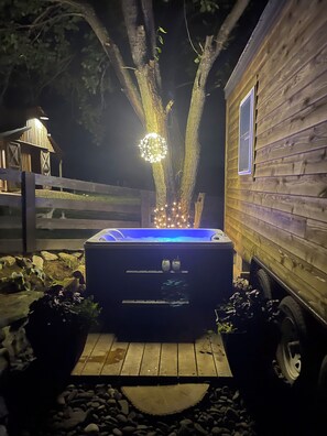 A hot tub in front of a wooden cabin with a tree in the background. - Luxury tiny home farm stay on historic property with hot tub in Stephens City (Stephens City)