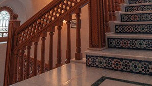 A wooden staircase with intricate balusters and a geometric tile pattern on the steps. - Abraj Bladi Resort (Marrakech)