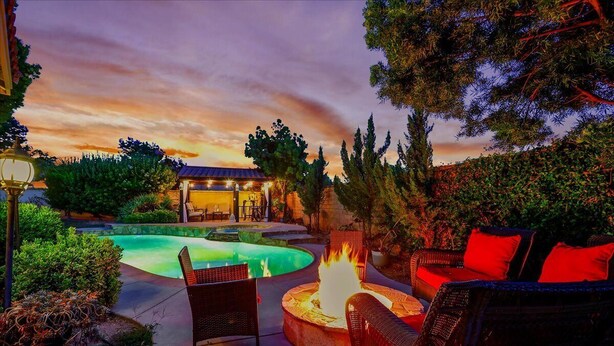 A pool area with a fire pit and outdoor furniture.
