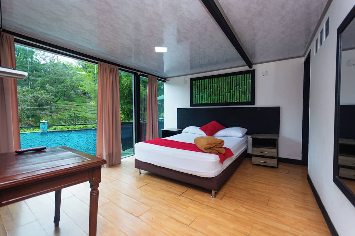 Une chambre moderne avec un lit, une table de chevet et une vue sur une piscine.