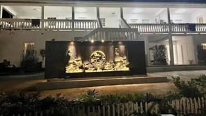 Un edificio moderno con una gran escultura iluminada en primer plano.