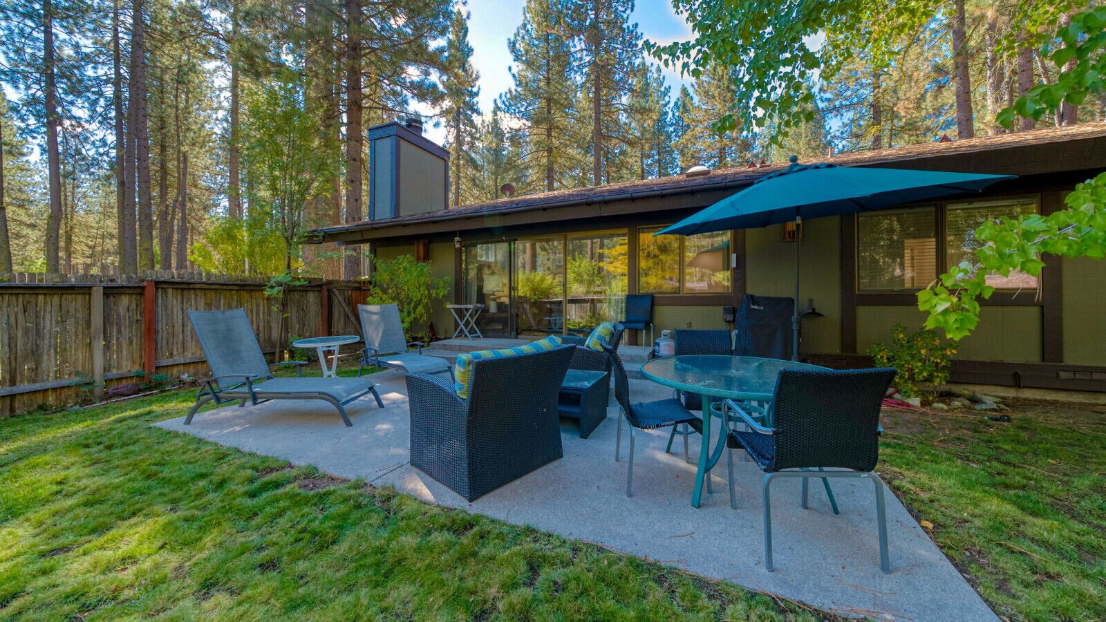 An outdoor patio with a dining set, chairs, and a table.