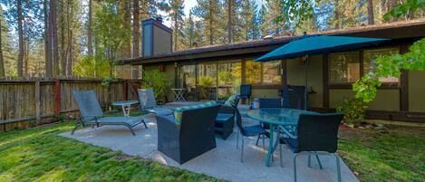 An outdoor patio with a dining set, chairs, and a table.