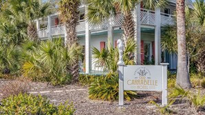 The Carrabelle Hotel with a white exterior, multiple balconies, and surrounded by tropical vegetation. - The Old Carrabelle Hotel (Carrabelle)