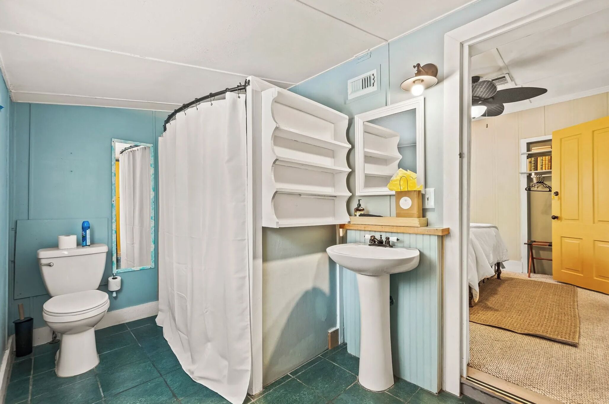 A bathroom with a toilet, sink, and shower curtain.