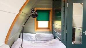 A bedroom with a bed, a desk, a lamp, and a window. - Romantic Cosy Cabin with Hot Tub in Cumbria (Brampton)