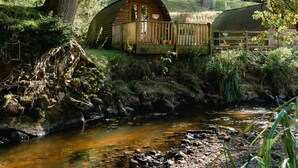 A rustic cabin by a stream in a forest. - Romantic Cosy Cabin with Hot Tub in Cumbria (Brampton)