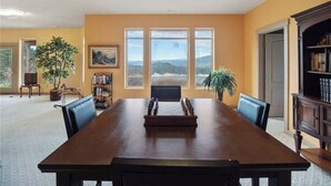 A conference room with a long table, chairs, a bookshelf, and a painting. - 8,500 sq.ft. Luxurious River/Mountain View house (Kettle Falls)