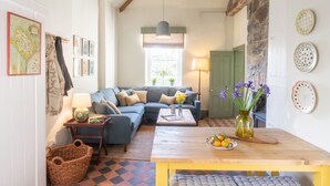 A cozy living room with a blue sofa, a wooden coffee table, and a map on the wall.