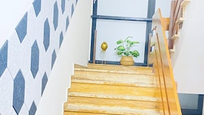A wooden staircase with a geometric patterned wall on one side. - Gästehaus Tilly (Hann. Muenden)