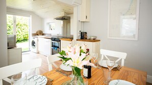 Una cocina moderna con comedor, lavadora y un amplio ventanal.