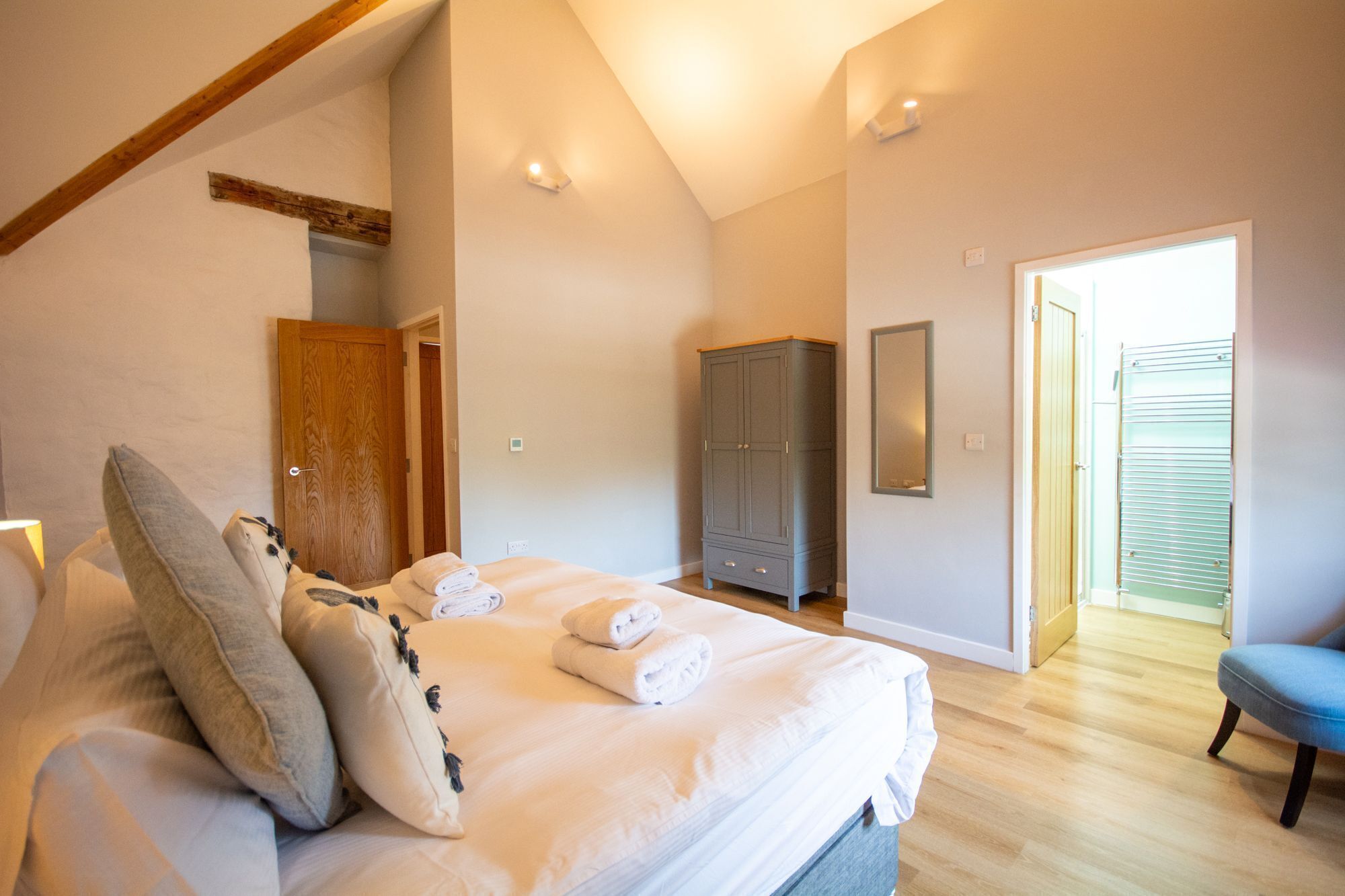 Un dormitorio con una cama, un armario, una puerta y una silla.