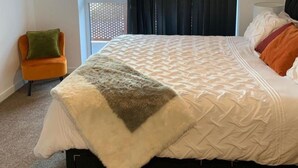 A bedroom with a bed, a chair, and a window with curtains. - Posh 1 Bed Flat-direct Links to Central London (Grays)