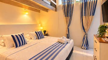 A modern bedroom with a large bed, ceiling fan, and a view of the sky.