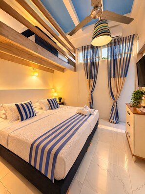 Een moderne slaapkamer met een groot bed, plafondventilator en uitzicht op de lucht.